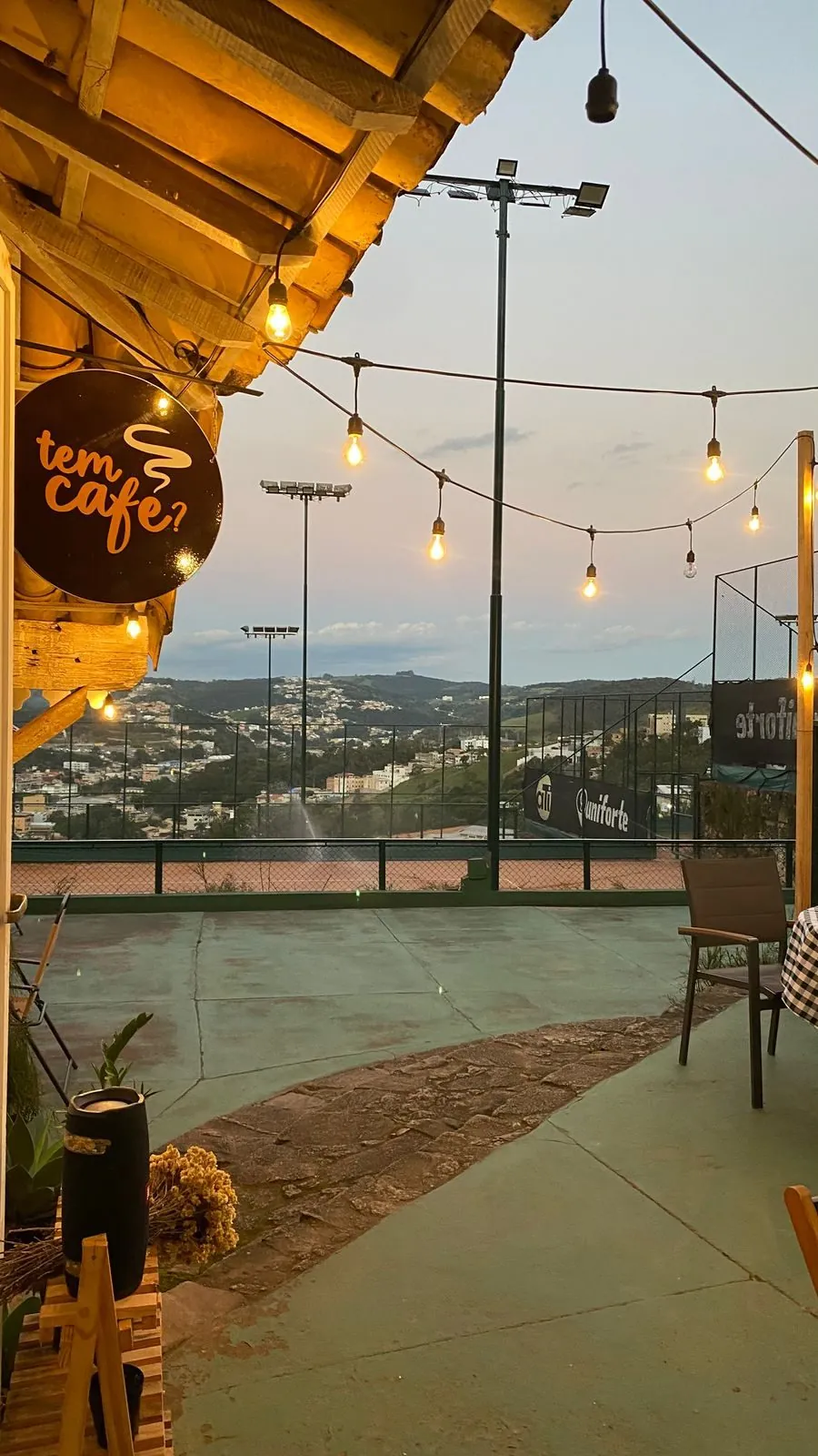Placa do Tem Café iluminada no fim de tarde